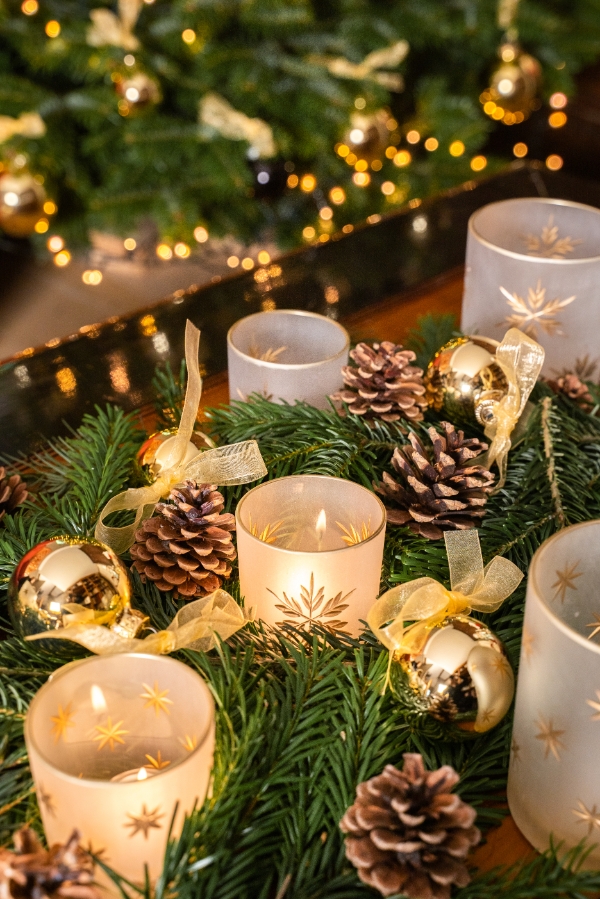 Kerstboom versierd met kaarsen en dennenappels